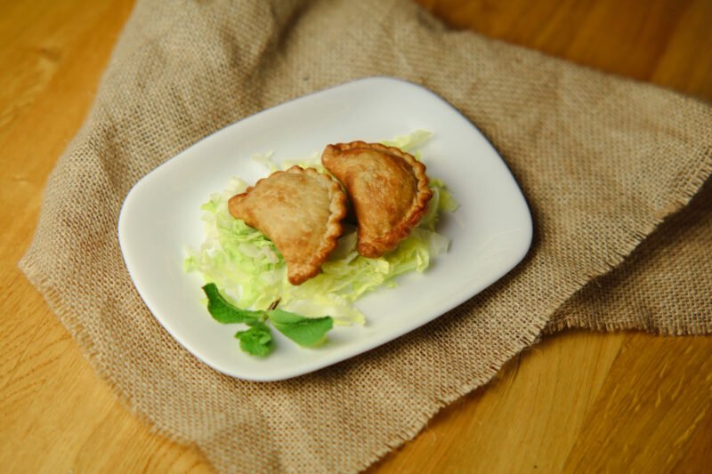 sambousek image Fried dough bites filled with beef, onion, pine nuts, and pomegranate sauce (2 pieces)