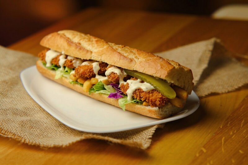 crispy chicken sandwich Baguette with fried chicken fillet, fries, salad, pickle, garlic sauce.